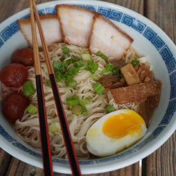 A bowl of Asahikawa ramen, with char siu pork belly, menma, green onion, softboiled egg, and pickled plums